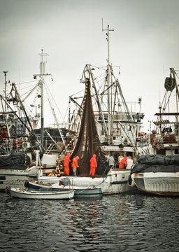 Fisherman Crew Fixing Nets On Fishing Boat