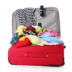 Open red suitcase with clothing isolated on a white