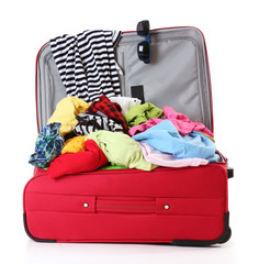 Open red suitcase with clothing isolated on white