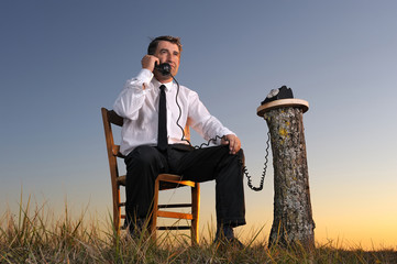 un businessman téléphonant, en pleine nature
