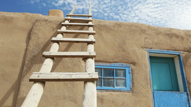 Wooden Ladder Against Adobe Building