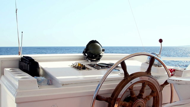 View from boat wheelhouse on a sea and blue sky.