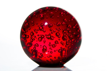 Red crystal ball with buble in it on white
