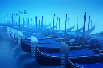 Raw of gondolas in thick fog at early morning;