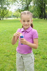 Little girl in the park blowing bubbles