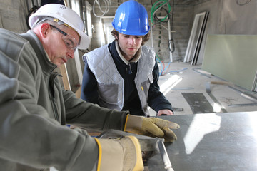 Zinc worker and apprentice in workshop