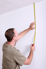 Man measuring wall