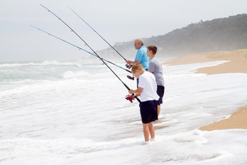 grandpa and grandsons fishing on beach