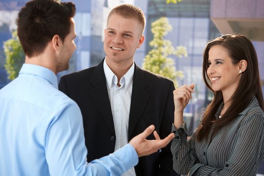 Young businesspeople talking outside of office