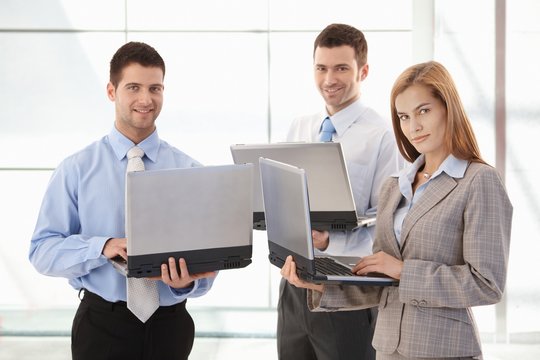 Confident businessteam working on laptop smiling