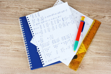 Math on copybook page on a wooden table