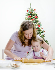 little girl and mother are preparing Christmas cookies