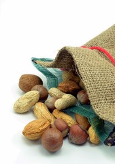 Mixed nuts in an open hessian bag on white background