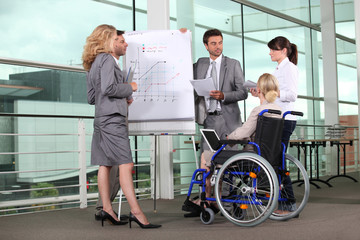 Businesswoman in wheelchair with colleagues