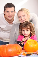 Fototapeta na wymiar Family carving pumpkins together