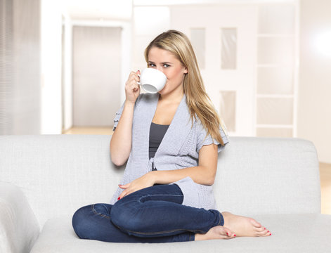 Young woman drinking coffee or tea in a cup