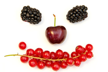 funny face from different berries on a white background