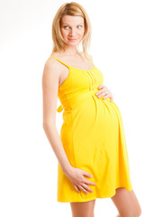 Beautiful pregnant woman holding her belly on white