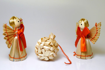 Two christmas decoration angels with a bag made of straws