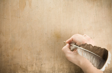 writing hand with pen feather