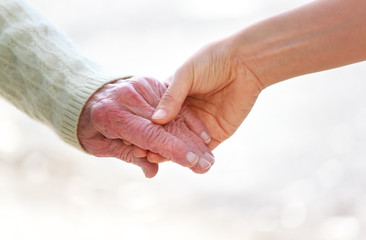 Senior and young holding hands