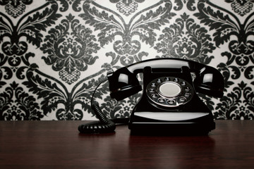 Vintage telephone over ornate wallpaper with copy space