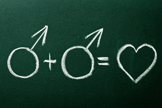 Homosexual copule in love symbols on green blackboard