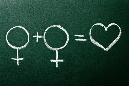 Homosexual copule in love symbols on green blackboard