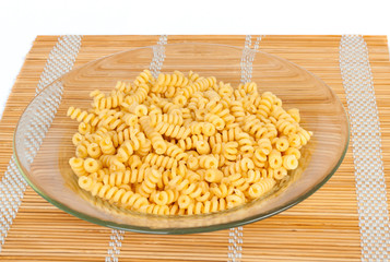 Macaroni in a transparent plate on straw mat