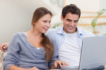 Fototapeta premium Delighted couple using a laptop