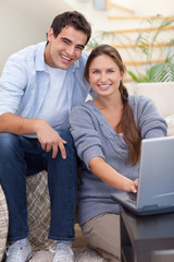 Portrait of a radiant couple using a notebook