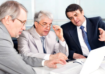 Portrait of three businessmen at the computer.
