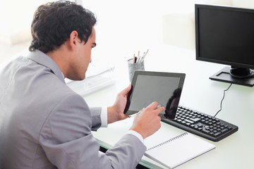 Businessman looking at his tablet in his office