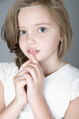 Naklejka premium Portrait of a cute little girl with folded handles