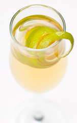 Yellow cocktail in glass with lemon twist