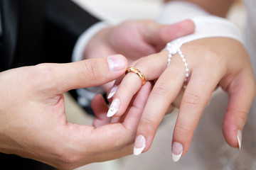 Newly-married couple on wedding dresses gold rings