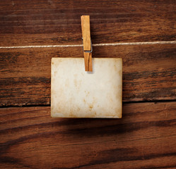 grunge note paper and clothes peg on wood