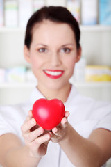 Closeup on heart in pharmacist`s hands.