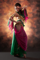 Beautiful exotic belly dancer woman a rot-green costume
