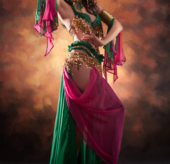 Beautiful exotic belly dancer woman a rot-green costume