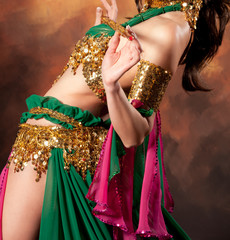 Beautiful exotic belly dancer woman a rot-green costume