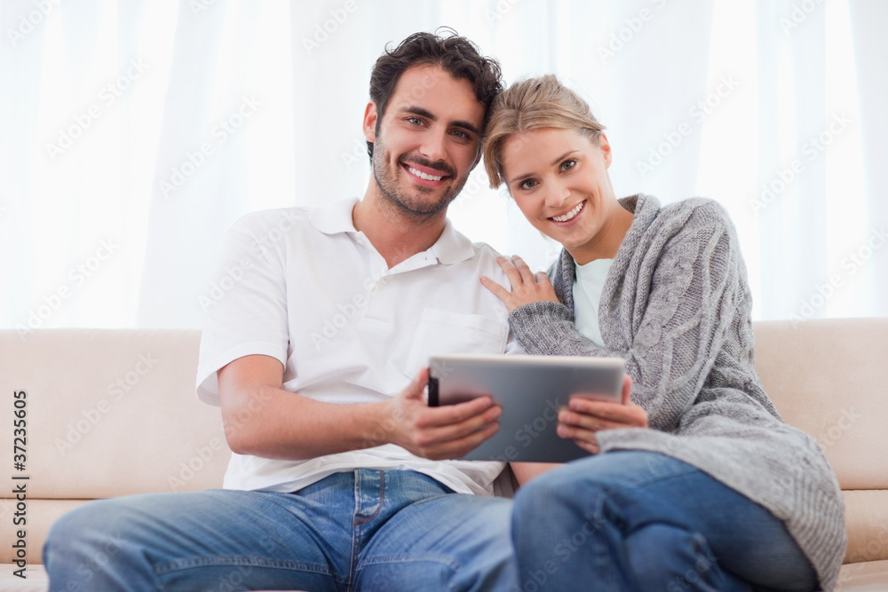 Aufkleber charming couple using a tablet computer