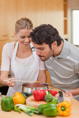 Portrait of a happy couple preparing a sauce