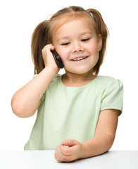 Cute little girl is talking on cell phone