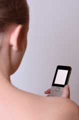 A young girl is holding a cell phone.