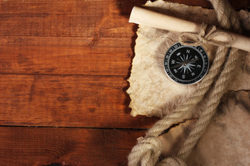 old paper, compass and rope on a wooden table