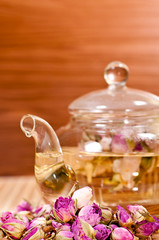 Obraz na płótnie Canvas Pink rose tea in a glass teapot close up