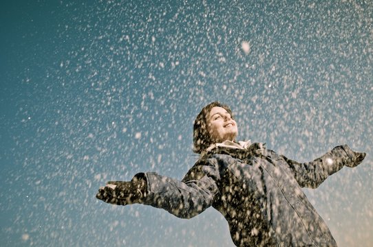 Enjoying winter - woman throwing snow