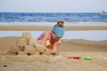 The child builds a sand castle on the beach - 37279821