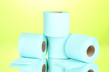 blue rolls of toilet paper on green background